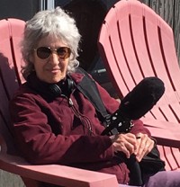 Barbara Bernstein, radio journalist, sitting in a chair, holding a microphone