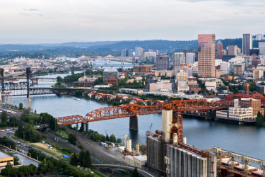 NW portland industrial area, photo of city scape and Broadway bridge which is red, Columbia River beneath