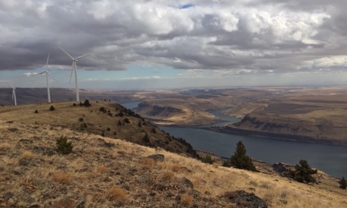 Landscape photo of Goldendale from a plateau featuring windmills in front of a stormy sky
