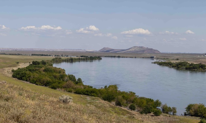 Image of the Hanford Reach of the Columbia River, with visible Nuclear reactors and Gable Mountain in the distance.
