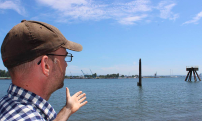 Dan Serres points out fossil fuel infrastructure along the Columbia River in Portland, Oregon, July 16, 2018. Thomson Reuters Foundation/Gregory Scruggs