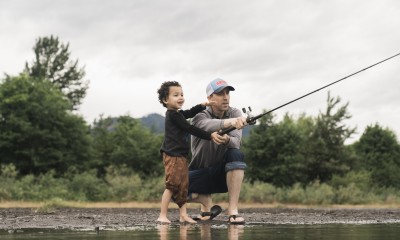 Miles Johnson and his toddler holding a fishing rod on a river bank