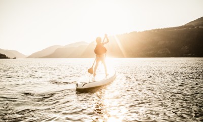 Child stand up paddle boarding on the Columbia River at sunset.
